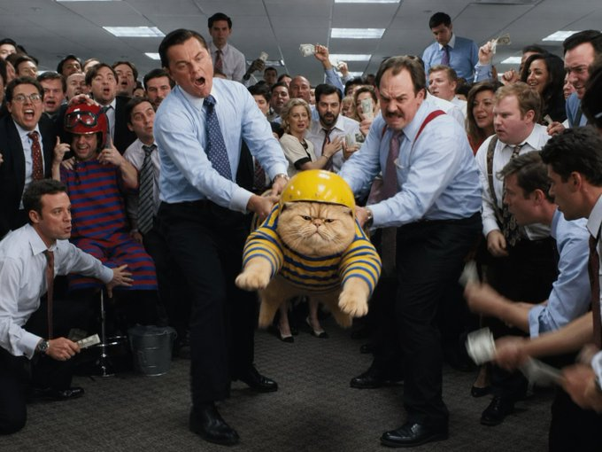 Fat cat in a striped shirt and helmet hoisted through a crowd of cheering brokers